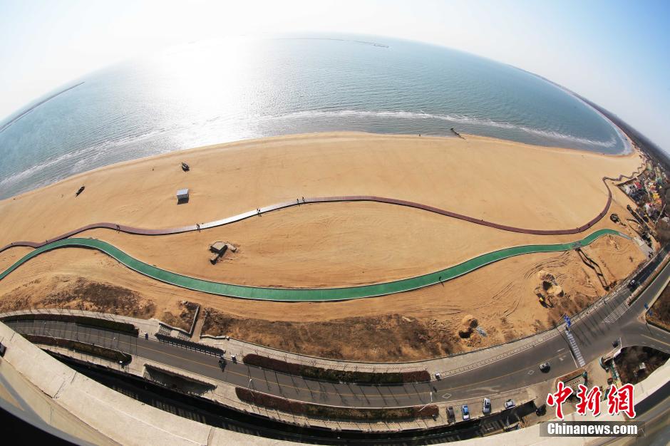 3月13日，秦皇島萬米臨海沙灘木棧道。據(jù)了解，該木棧道全長約4200米，與北戴河區(qū)原有的7500米木棧道對接后全線總長度1.17萬米，整個木棧道東起秦皇島體育基地游船碼頭，西至北戴河濕地公園，呈波浪形蜿蜒10.4公里海岸線。 中新社發(fā) 曹建雄 攝 CNSPHOTO
