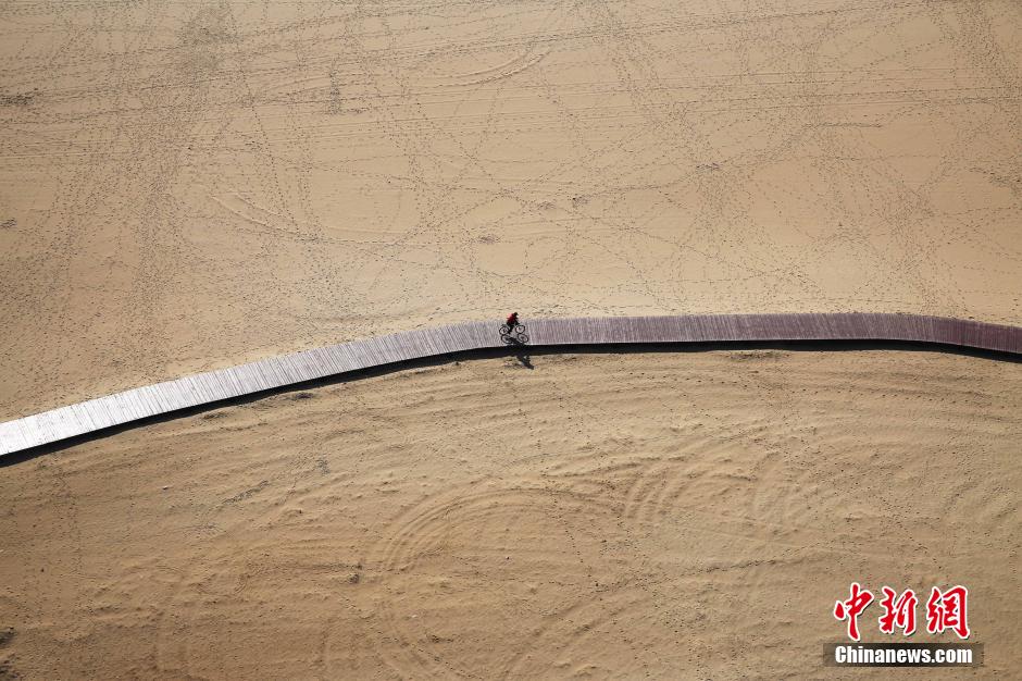 3月13日，秦皇島萬米臨海沙灘木棧道。據(jù)了解，該木棧道全長約4200米，與北戴河區(qū)原有的7500米木棧道對接后全線總長度1.17萬米，整個木棧道東起秦皇島體育基地游船碼頭，西至北戴河濕地公園，呈波浪形蜿蜒10.4公里海岸線。 中新社發(fā) 曹建雄 攝 CNSPHOTO